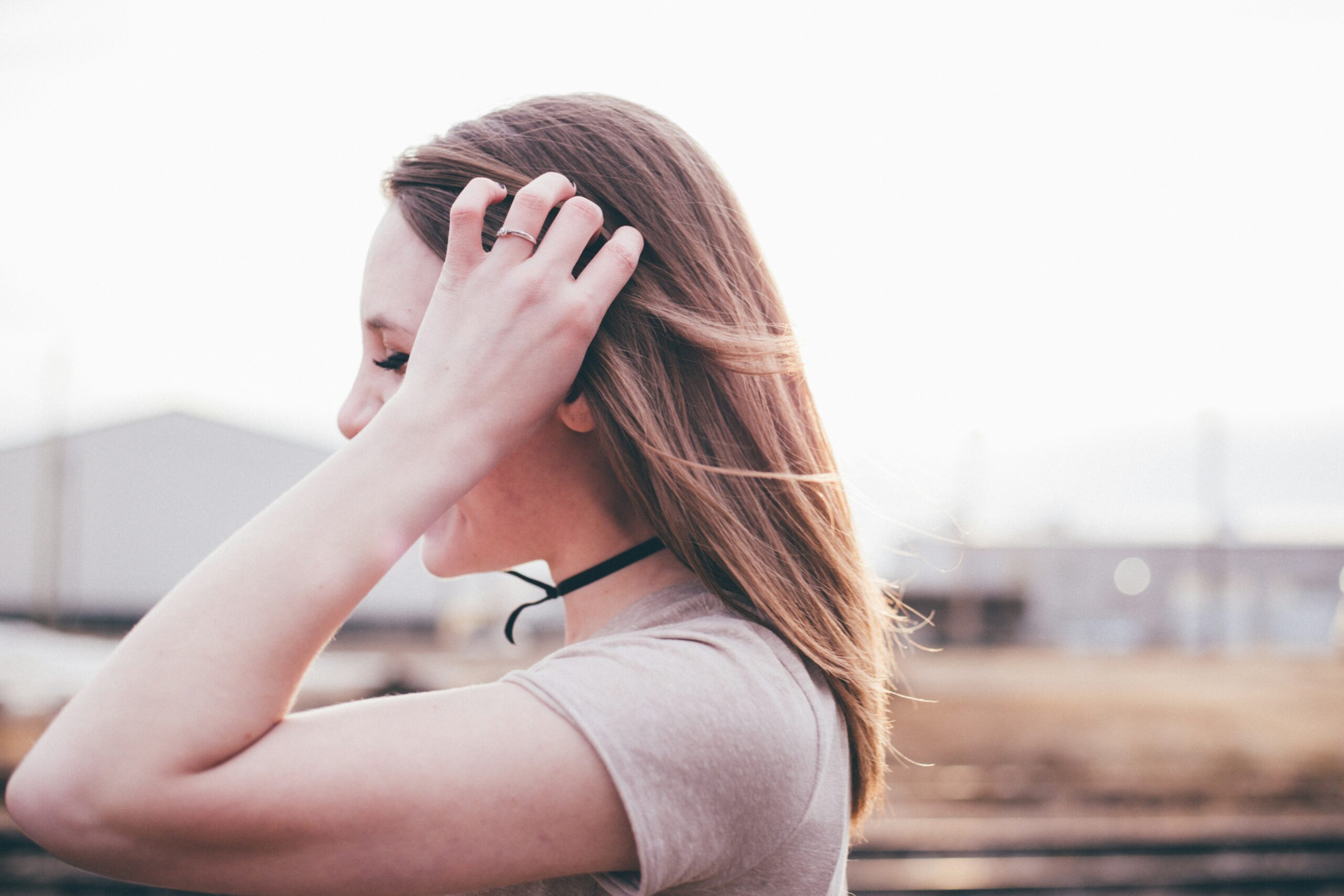 woman pushing her hair out of her face